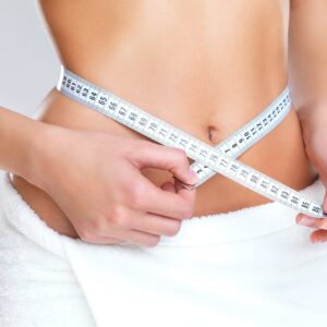 Photo of a woman measuring her waistline